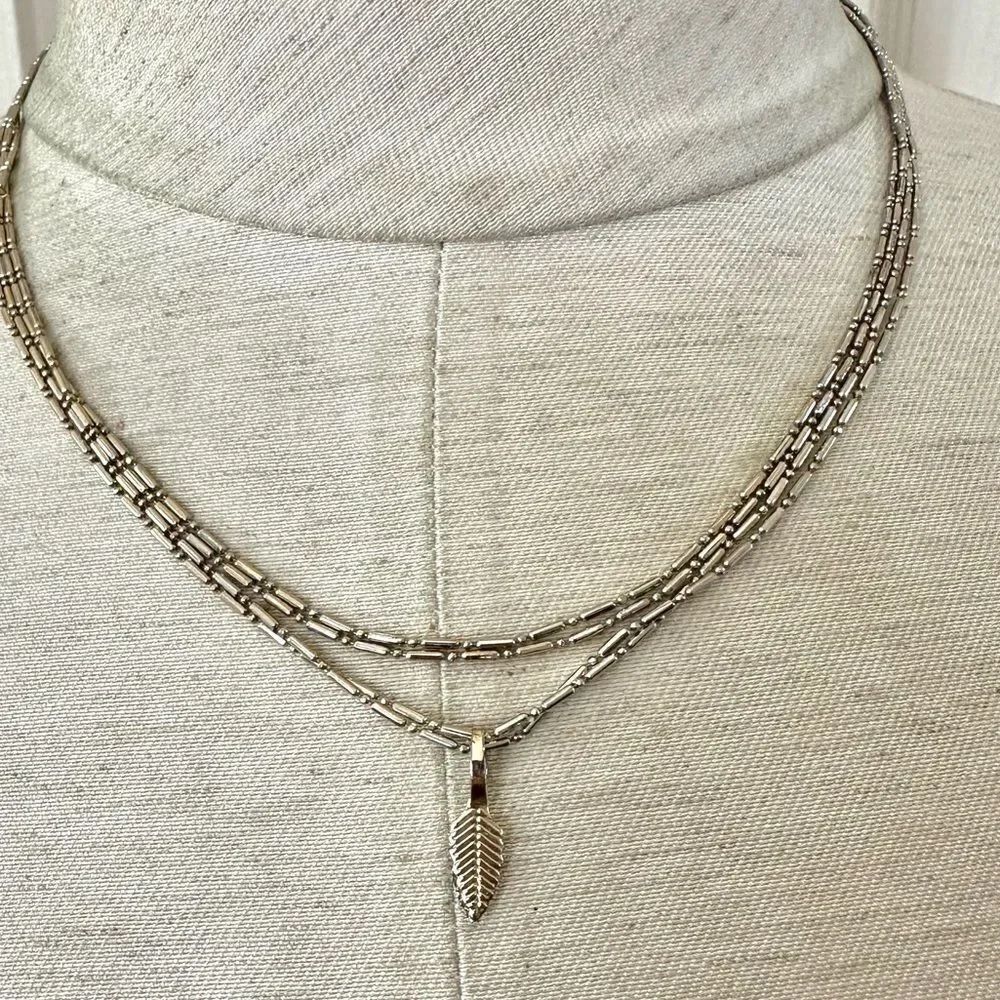 Long gold tone double chain small leaf pendant